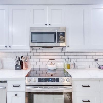 It is the picture of a kitchen which is all white in color.